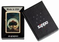 Model Zippo w złotej obudowie z pięknym krajobrazem i wyrazistym drzewem.