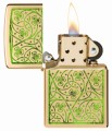Zippo w kolorze złota z symbolicznymi, zielonymi elementami szczęścia.
