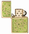 Złota zapalniczka Zippo z dekoracyjnym wzorem zielonych liści koniczyny.