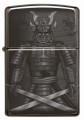 Model Zippo w ciemnym kolorze z ilustracją samuraja i pionowym pismem japońskim.