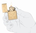 dłoń z zapalniczką Zippo w złotym kolorze